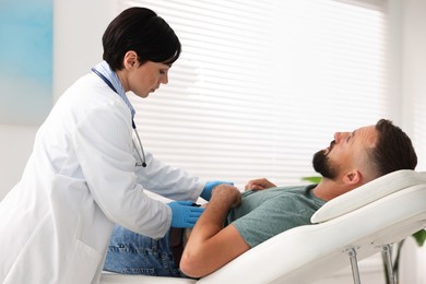 Photo of Gastroenterologist examining patient with stomach pain in clinic