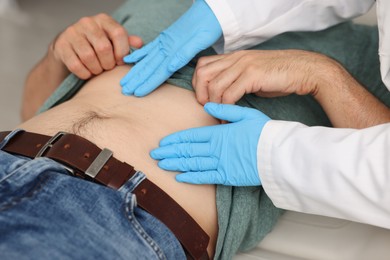 Photo of Gastroenterologist examining patient's stomach in clinic, closeup
