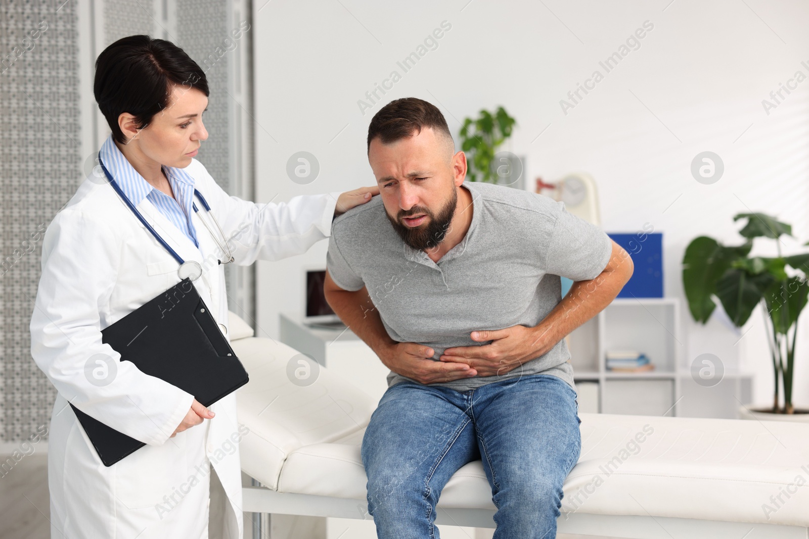 Photo of Gastroenterologist consulting patient with stomach pain in clinic