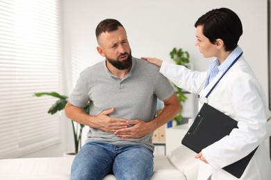 Photo of Gastroenterologist consulting patient with stomach pain in clinic