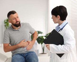 Photo of Gastroenterologist consulting patient with stomach pain in clinic