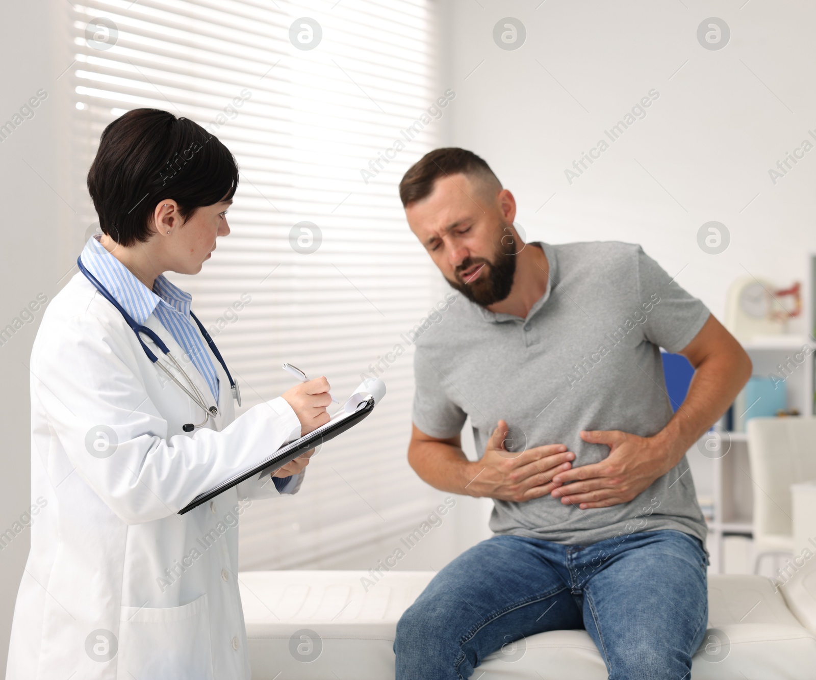 Photo of Gastroenterologist consulting patient with stomach pain in clinic