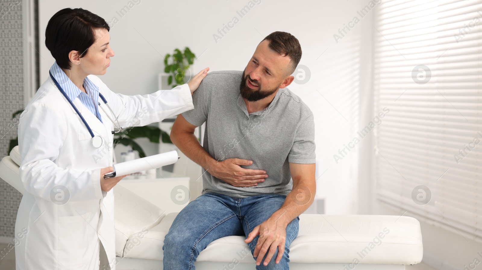 Photo of Gastroenterologist consulting patient with stomach pain in clinic