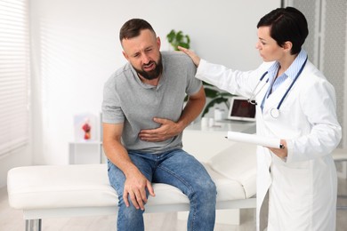 Photo of Gastroenterologist consulting patient with stomach pain in clinic