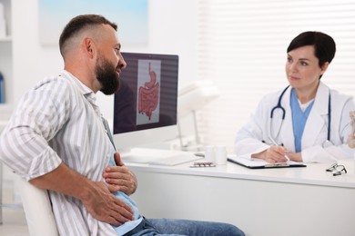Photo of Gastroenterologist consulting patient with stomach pain in clinic