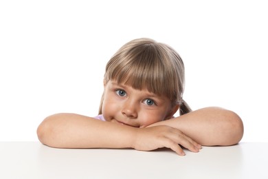 Photo of Curious little girl peeking over table against white background