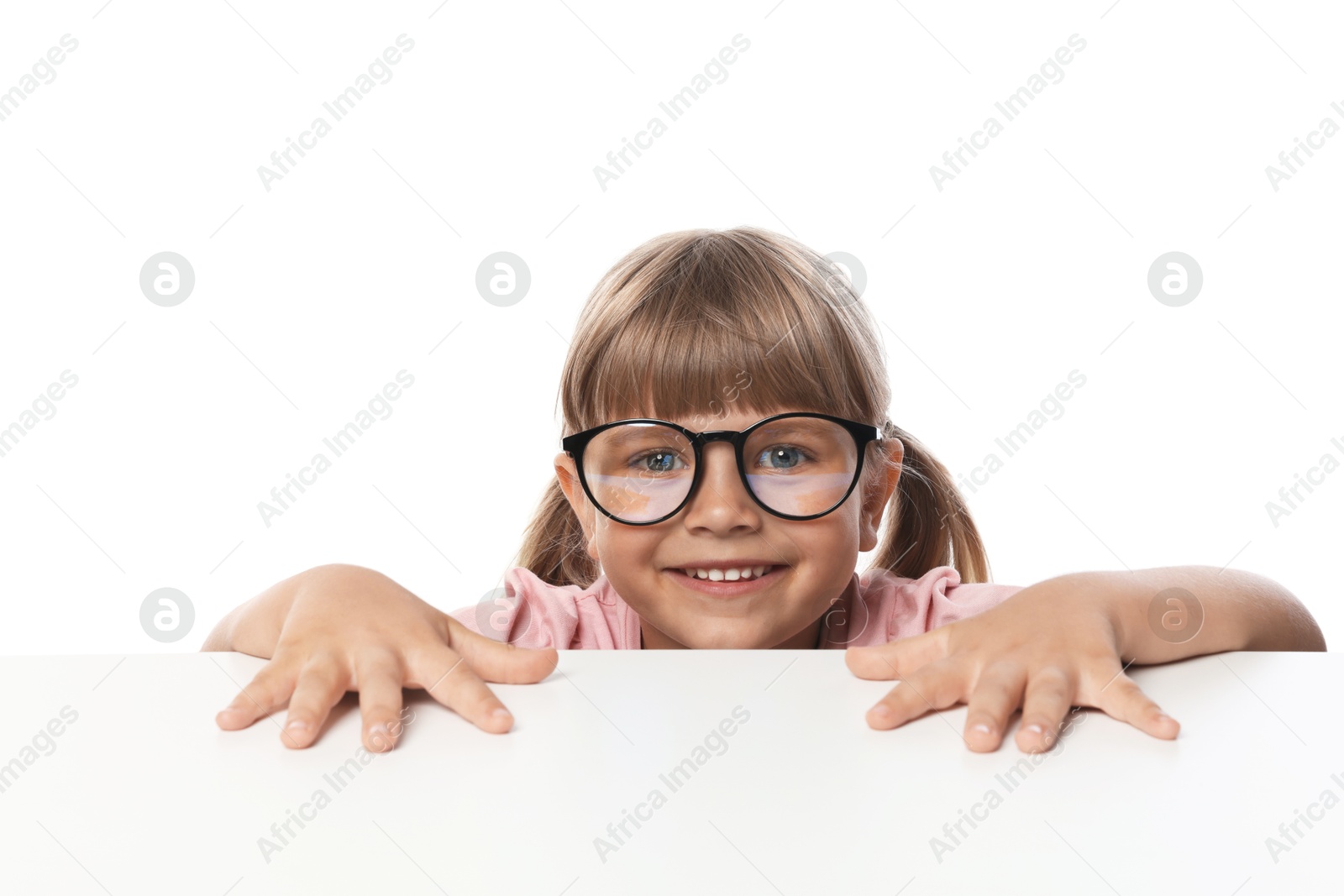Curious little girl peeking in glasses over table against white background Photo of Curious little girl peeking in glasses over table against white background