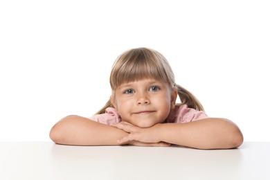 Photo of Curious little girl peeking over table against white background