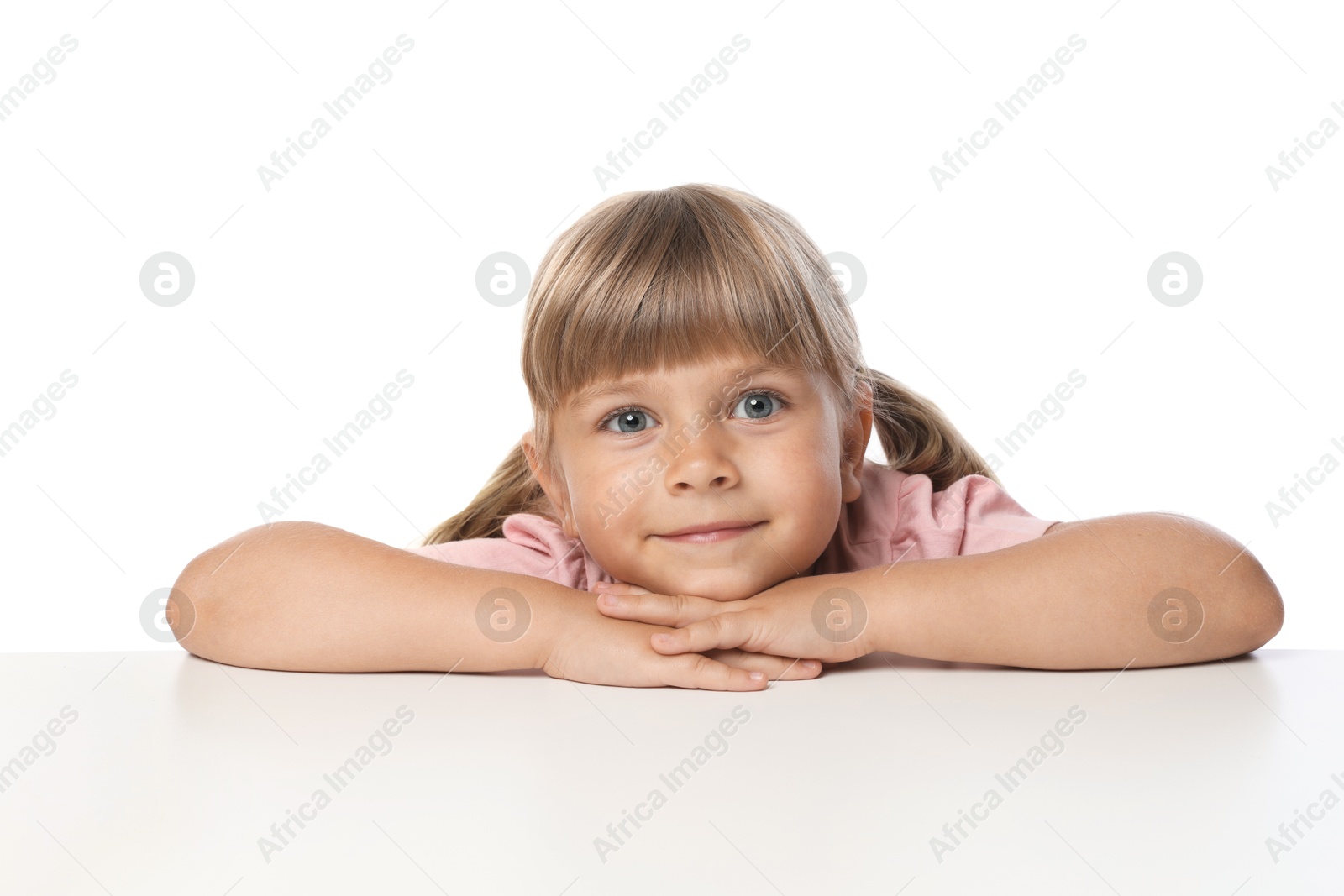 Curious little girl peeking over table against white background Photo of Curious little girl peeking over table against white background