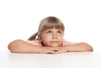 Photo of Curious little girl peeking over table against white background
