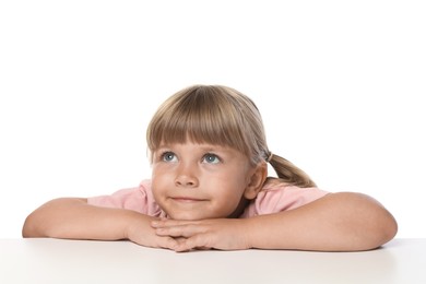 Photo of Curious little girl peeking over table against white background