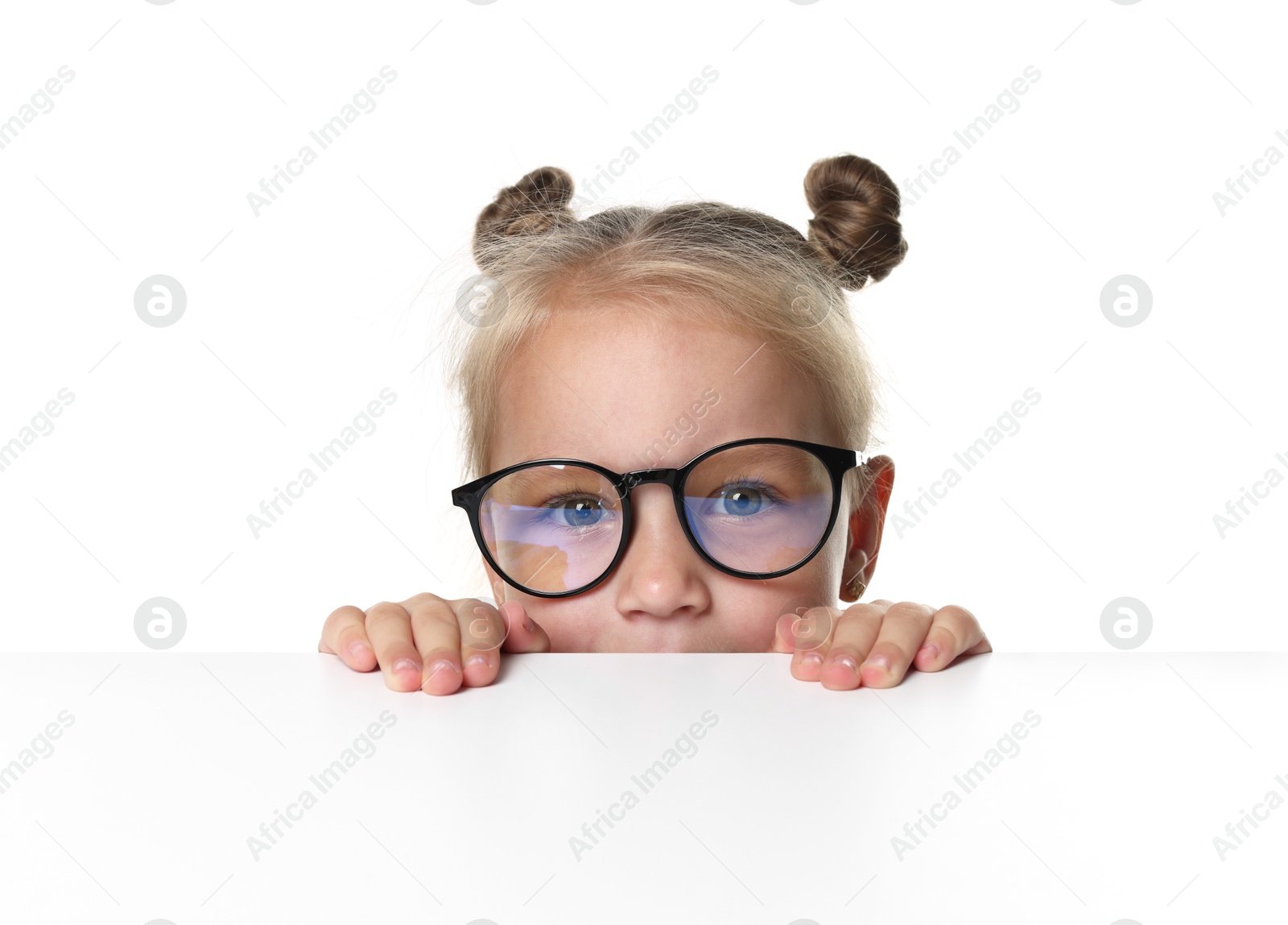 Photo of Curious little girl in glasses peeking over table against white background