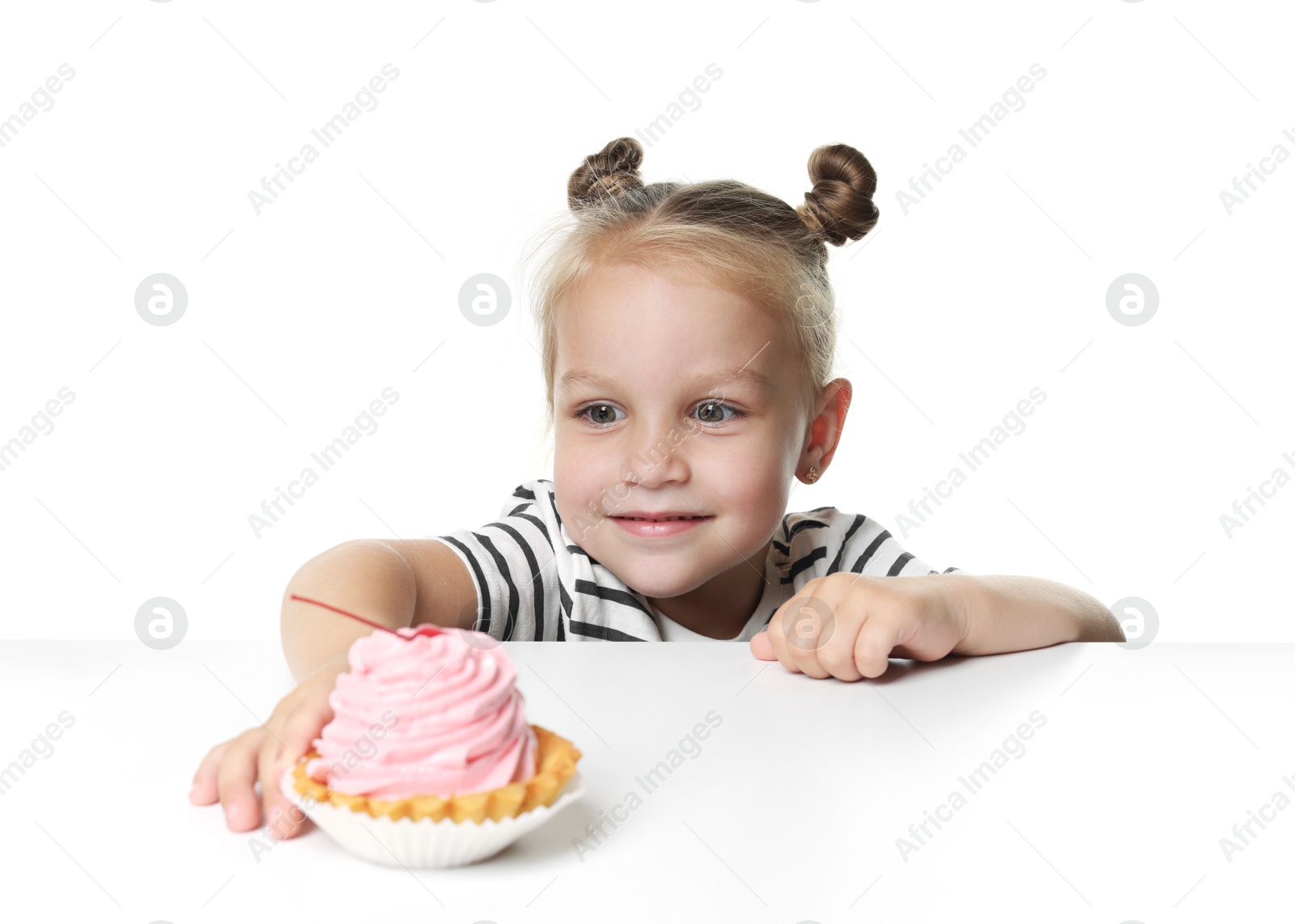 Cute little girl reaching for tasty dessert at table against white background Photo of Cute little girl reaching for tasty dessert at table against white background