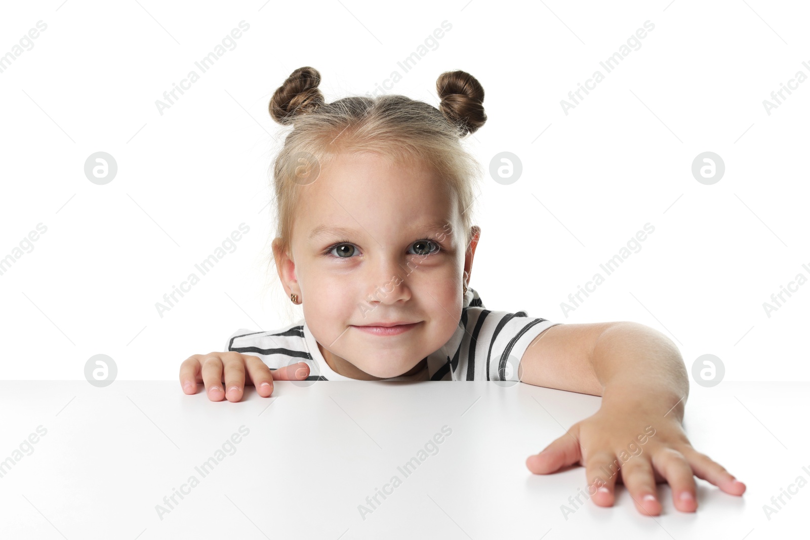 Photo of Curious little girl peeking over table against white background
