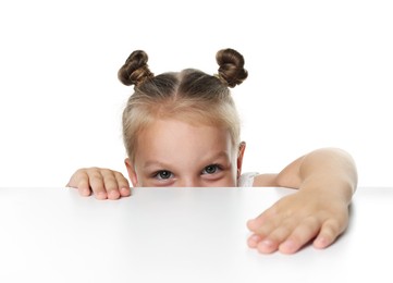 Photo of Curious little girl peeking over table against white background