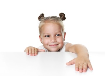Photo of Curious little girl peeking over table against white background
