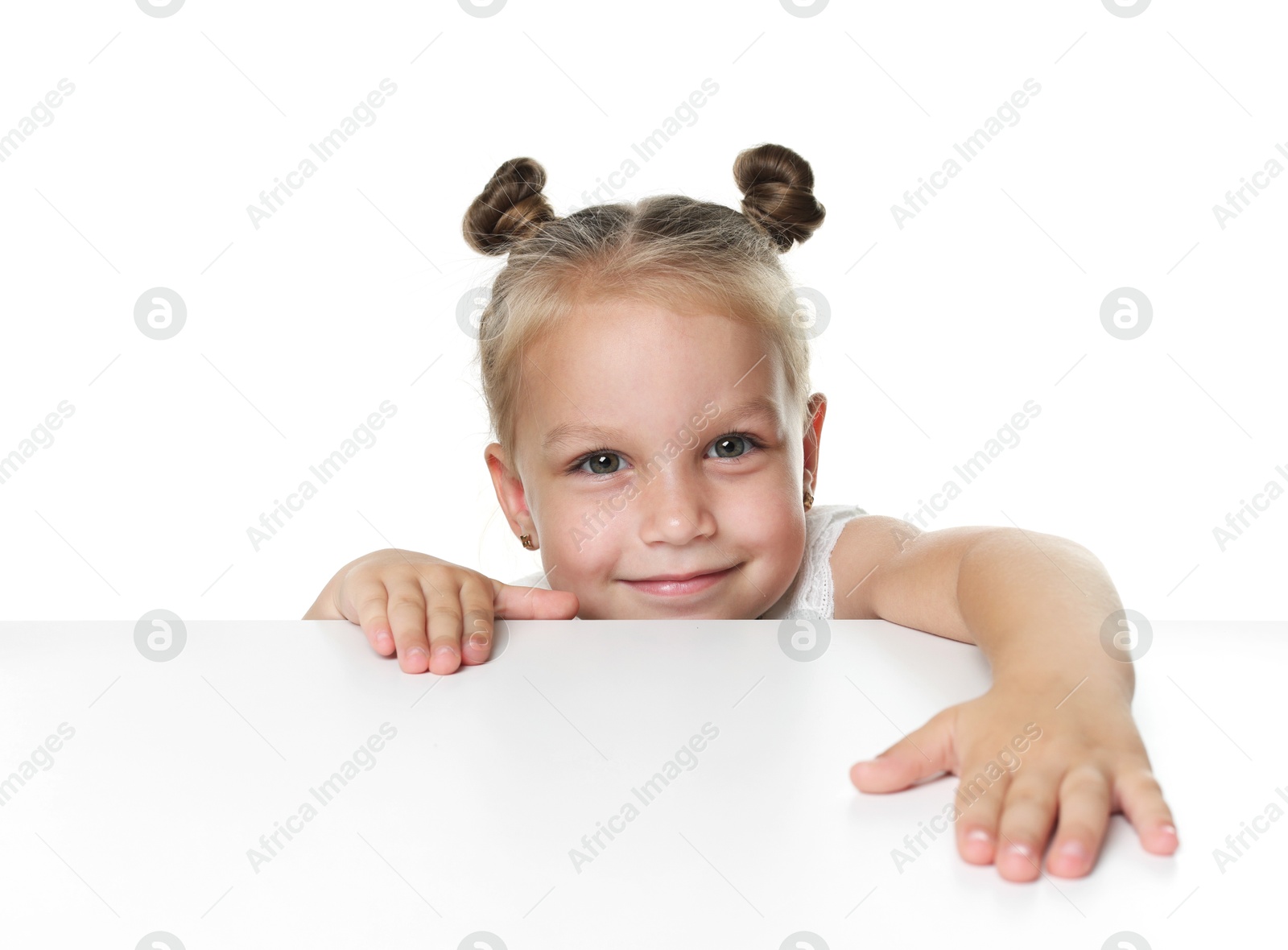 Photo of Curious little girl peeking over table against white background