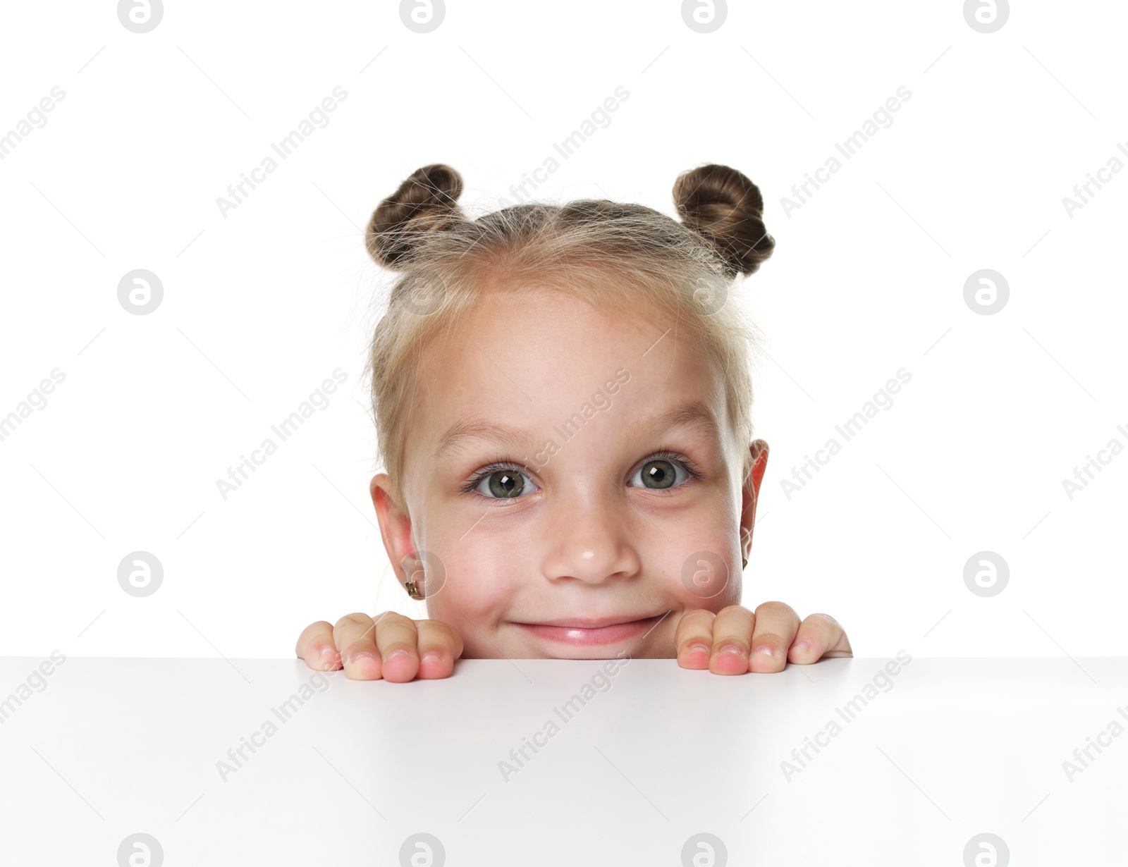 Photo of Curious little girl peeking over table against white background