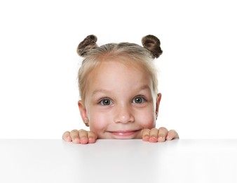 Photo of Curious little girl peeking over table against white background