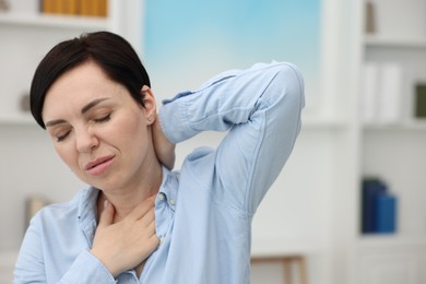 Photo of Woman suffering from neck pain at home