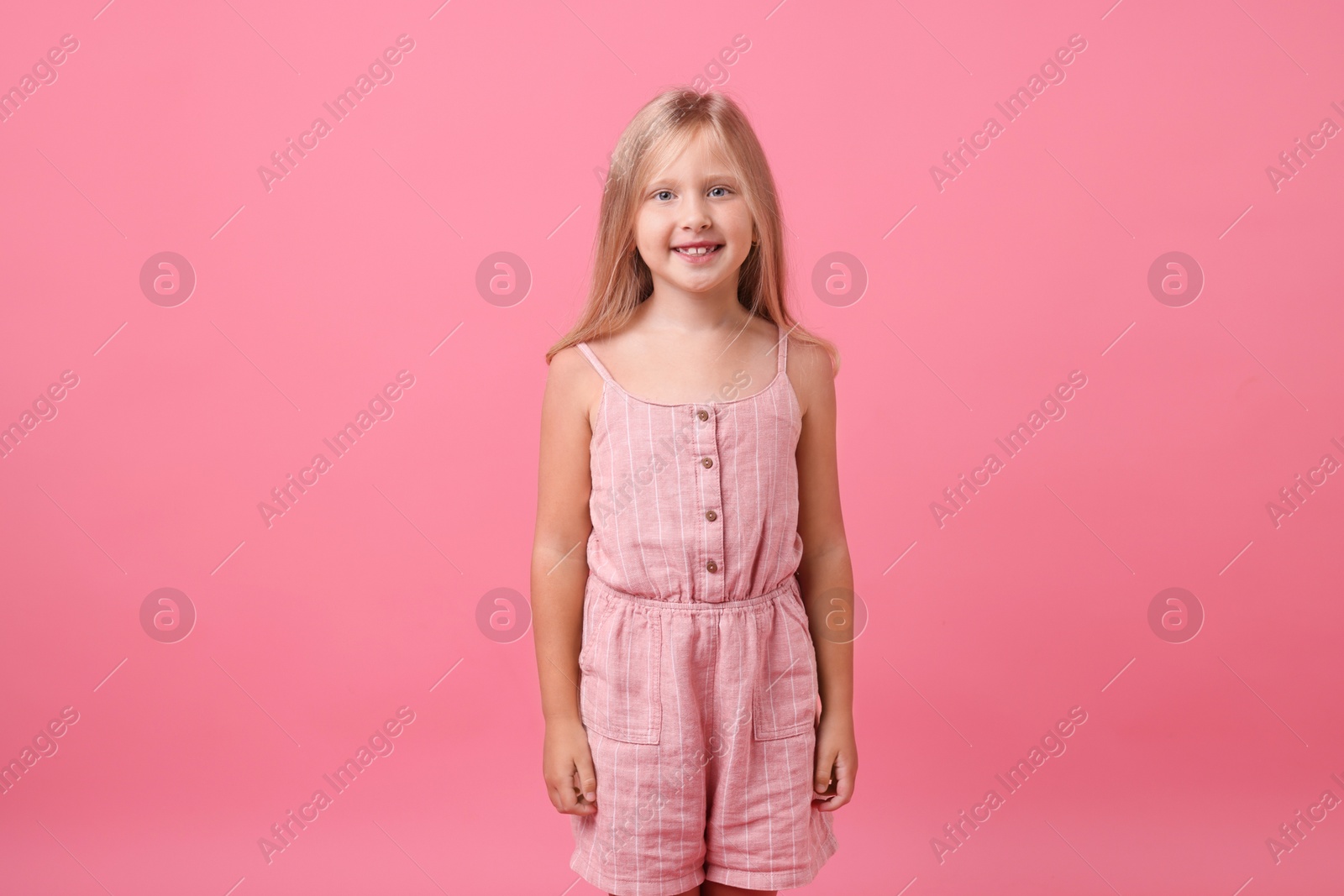 Portrait of smiling little girl on pink background Photo of Portrait of smiling little girl on pink background