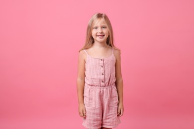 Photo of Portrait of smiling little girl on pink background