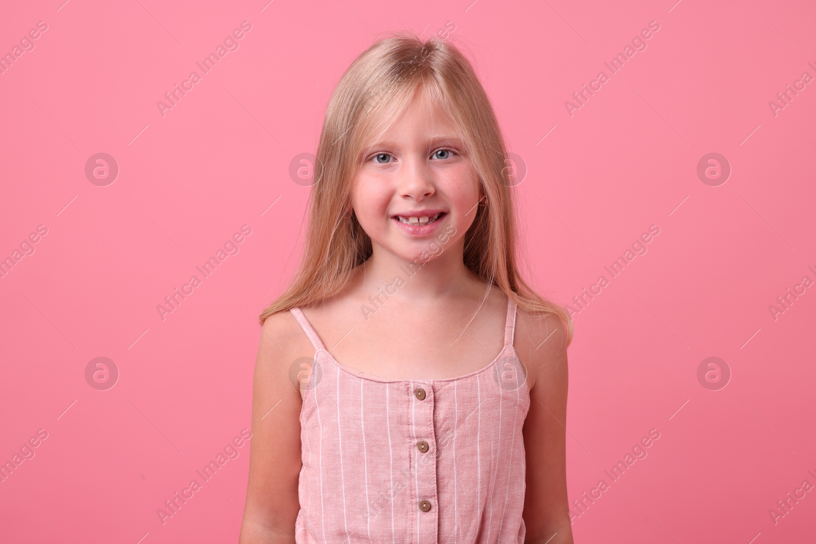 Photo of Portrait of smiling little girl on pink background