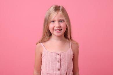 Photo of Portrait of smiling little girl on pink background