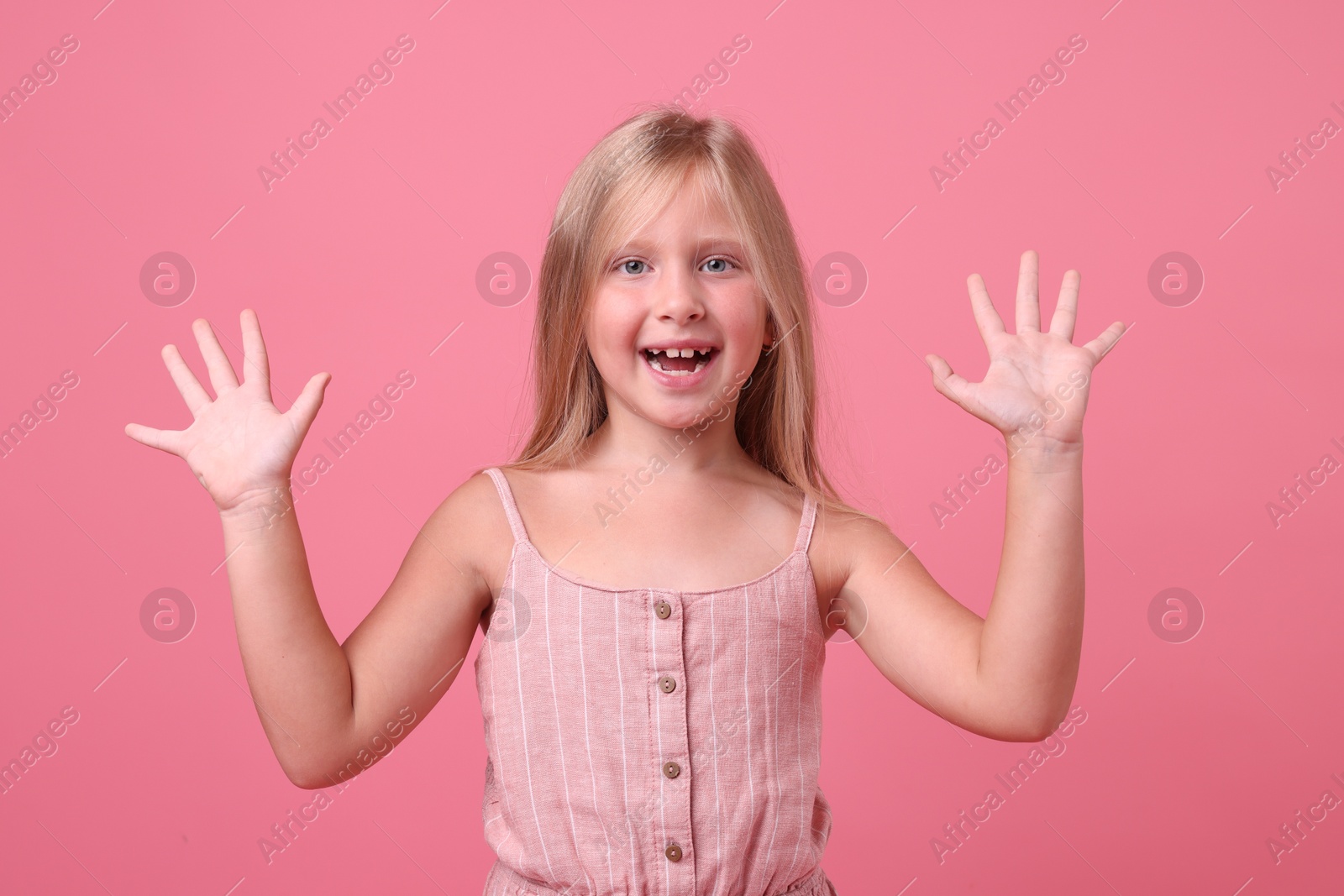 Photo of Cute little girl laughing on pink background
