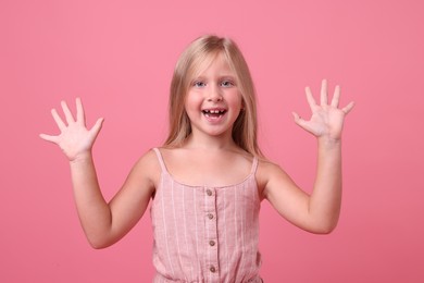 Photo of Cute little girl laughing on pink background