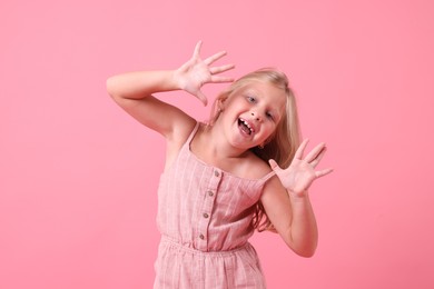 Photo of Cute little girl laughing on pink background