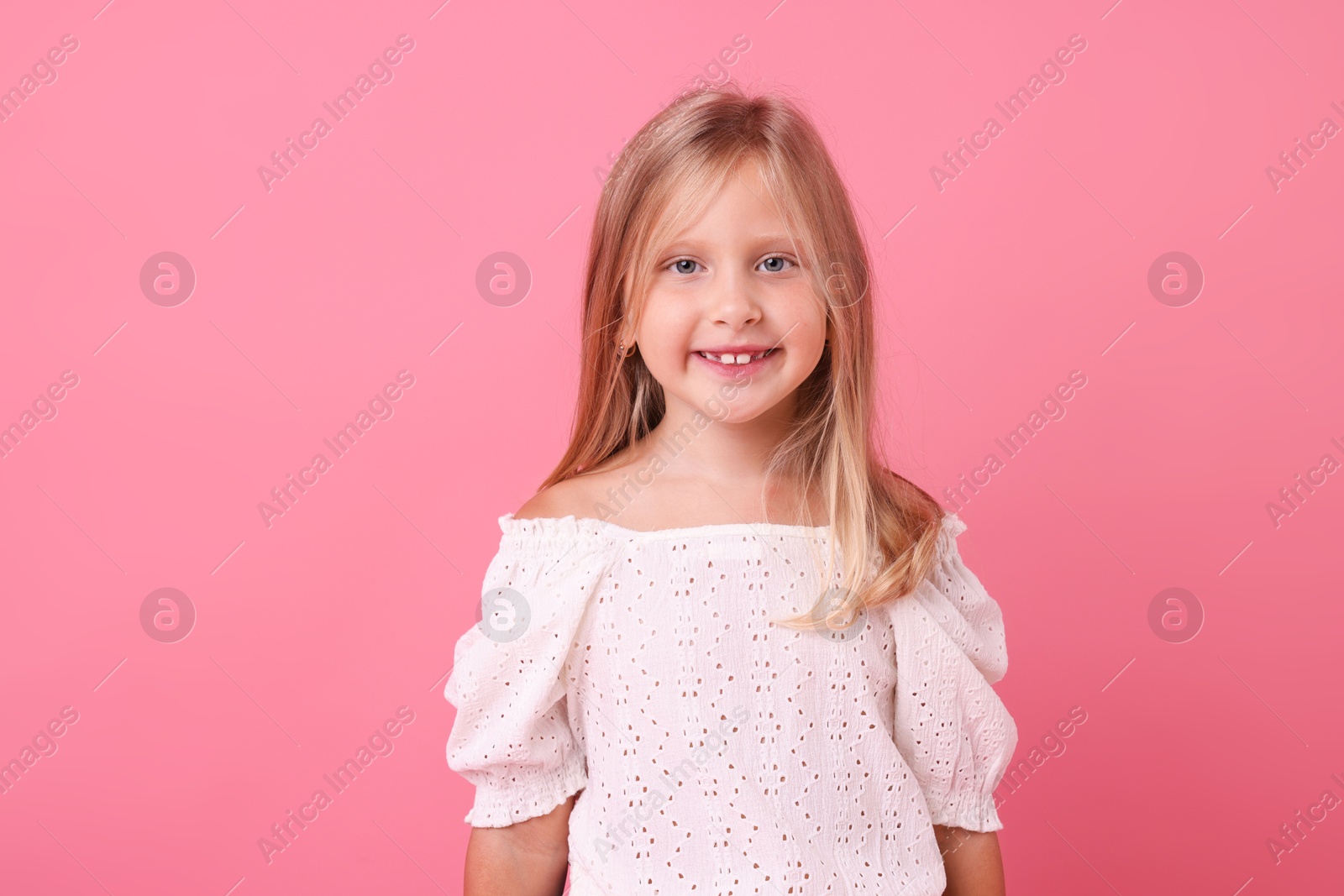 Photo of Portrait of smiling little girl on pink background
