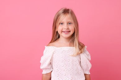 Photo of Portrait of smiling little girl on pink background