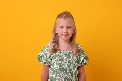 Photo of Portrait of smiling little girl on yellow background