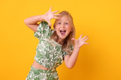 Photo of Emotional little girl on yellow background. Positive emotion