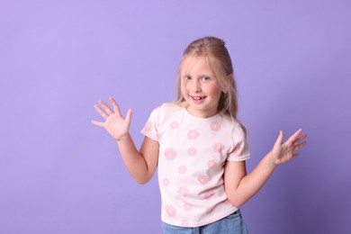Photo of Smiling little girl on violet background. Positive emotion
