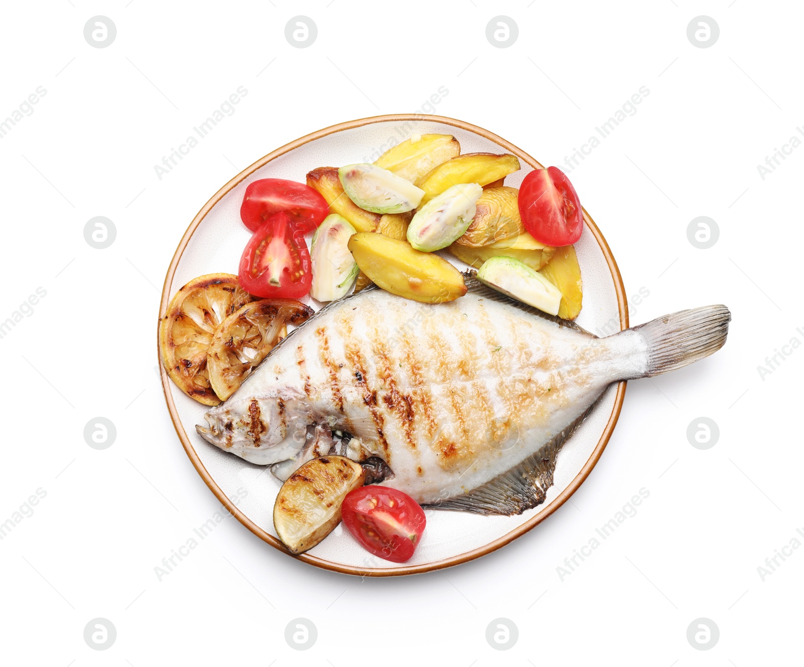 Photo of Tasty roasted flounder fish with potatoes, tomatoes and lemon slices isolated on white, top view. Homemade seafood dish
