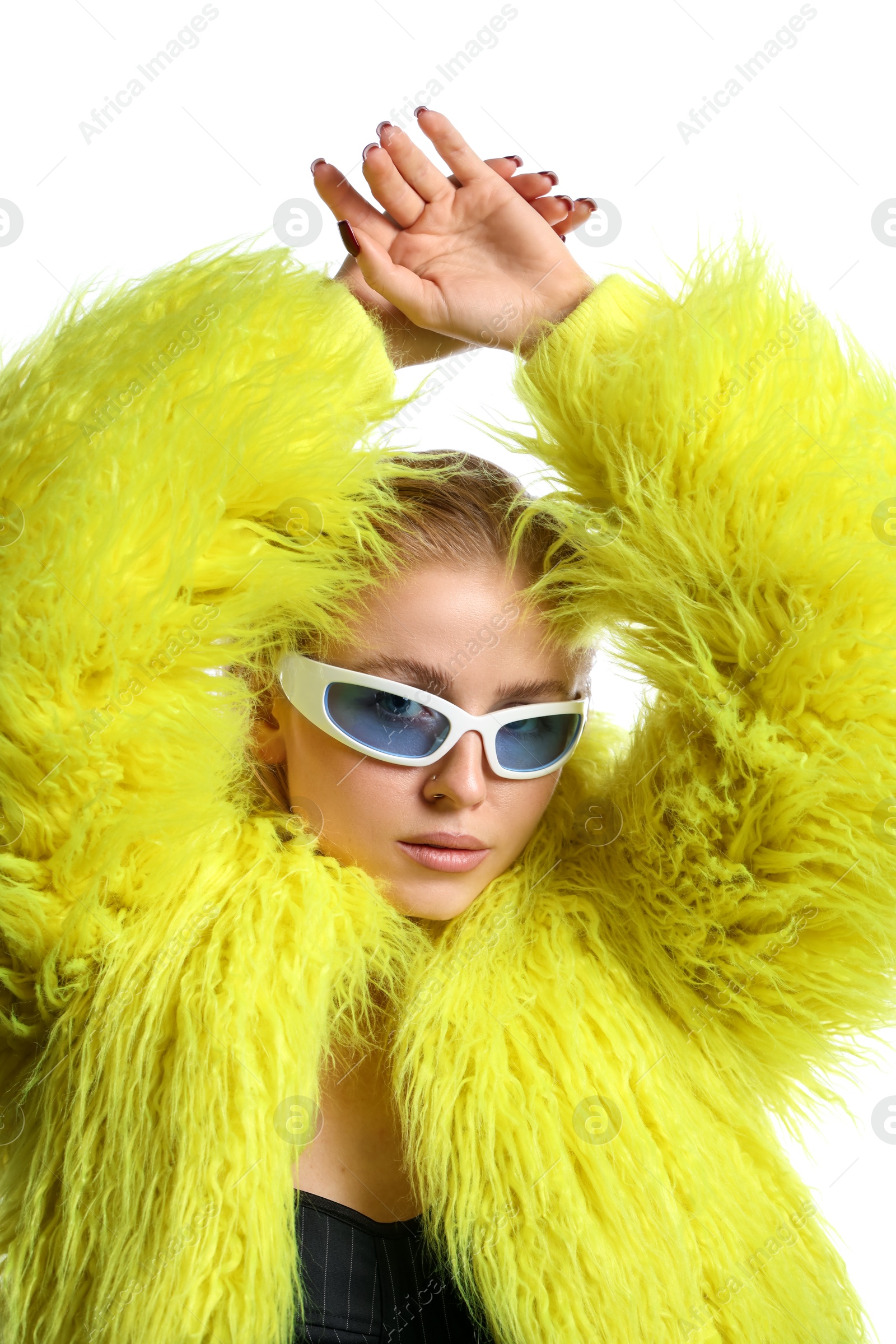 Photo of Beautiful woman in stylish sunglasses and fur coat posing on white background