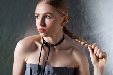 Photo of Beautiful woman with pigtail posing on metallic background