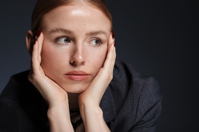 Photo of Beautiful woman posing on dark background, closeup