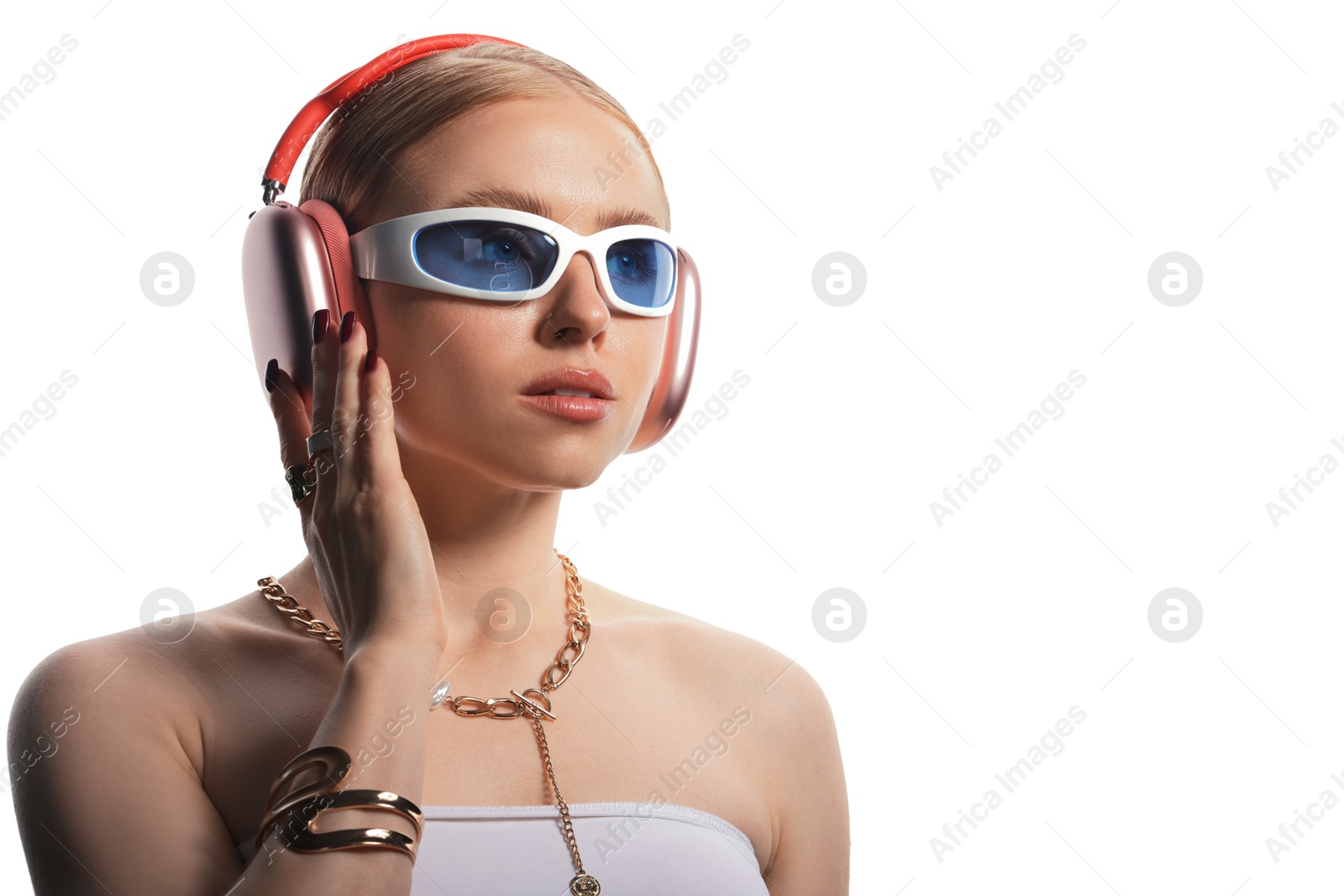 Photo of Beautiful woman in stylish sunglasses, bijouterie and headphones listening to music on white background