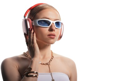 Photo of Beautiful woman in stylish sunglasses, bijouterie and headphones listening to music on white background