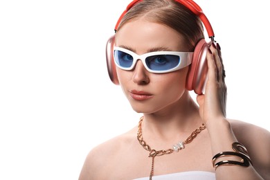 Photo of Fashionable portrait of beautiful woman in stylish sunglasses, bijouterie and headphones listening to music on white background