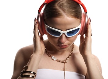 Photo of Beautiful woman in stylish sunglasses, bijouterie and headphones listening to music on white background
