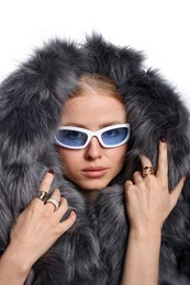 Photo of Fashionable portrait of beautiful woman in stylish sunglasses, rings and fur coat on white background
