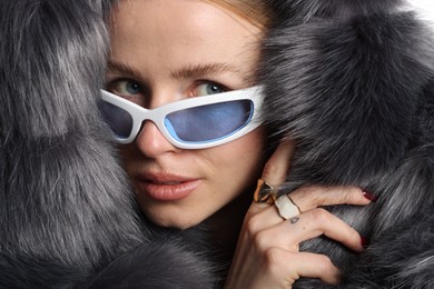 Photo of Fashionable portrait of beautiful woman in stylish sunglasses, rings and fur coat, closeup