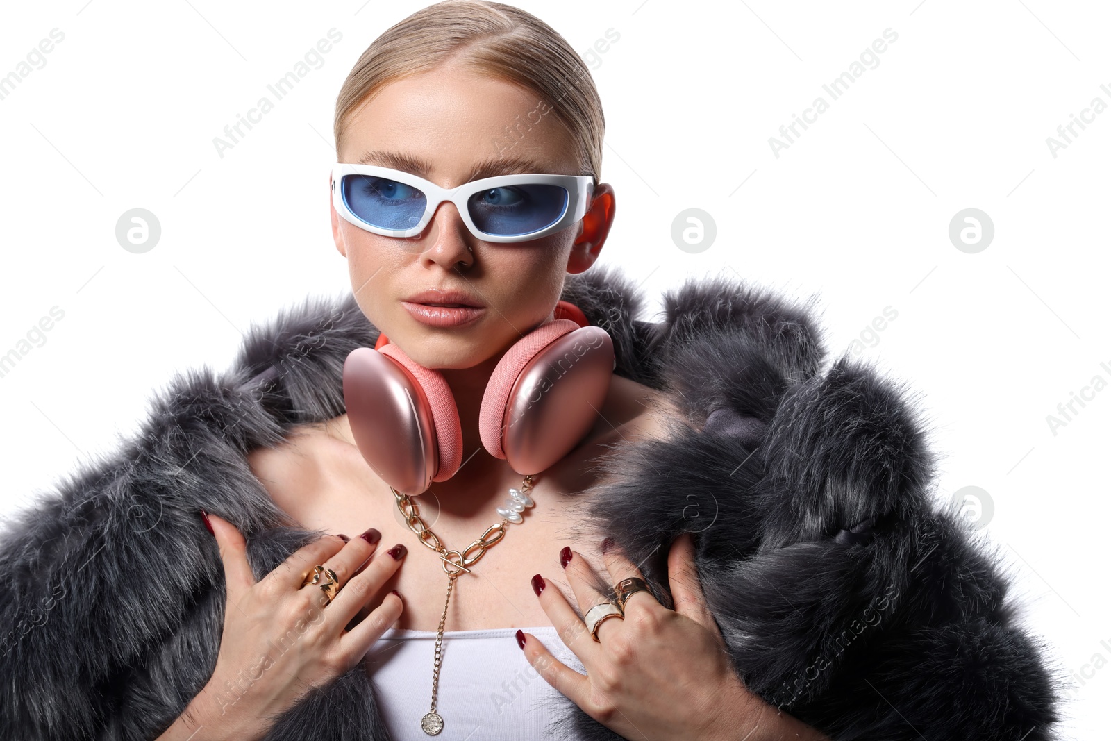 Photo of Beautiful woman in stylish sunglasses, bijouterie, fur coat and headphones on white background