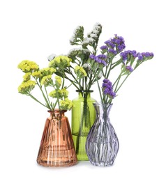 Photo of Different beautiful flowers in glass vases isolated on white