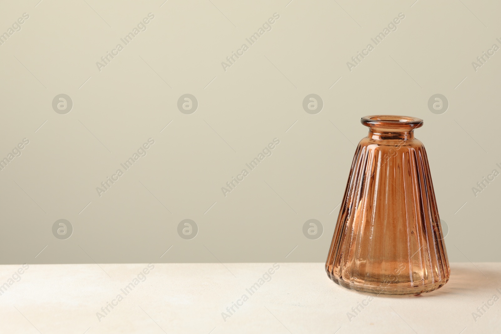 Photo of Beautiful glass vase on white table against light grey background, space for text