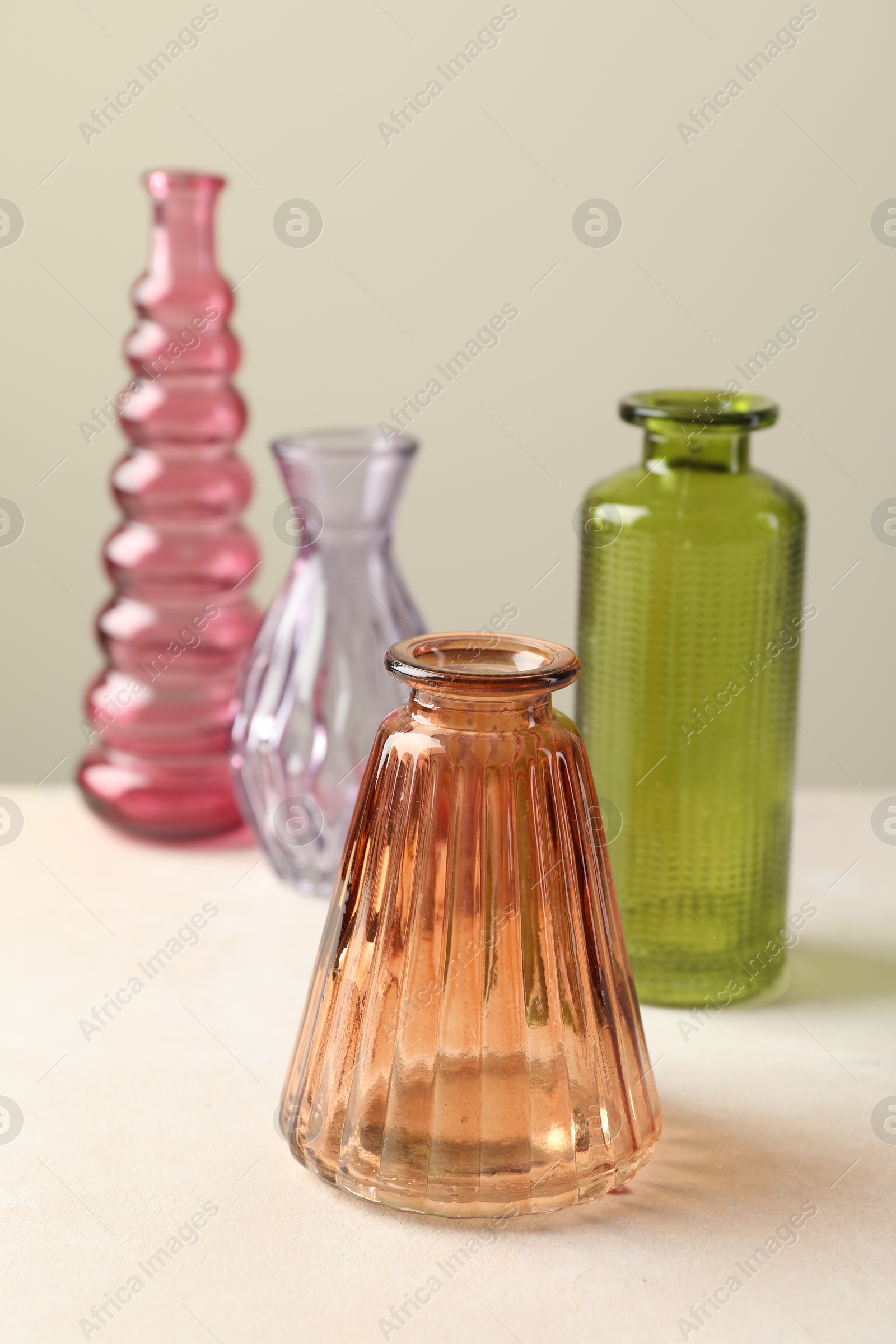Different beautiful glass vases on white table against light grey background, closeup Photo of Different beautiful glass vases on white table against light grey background, closeup